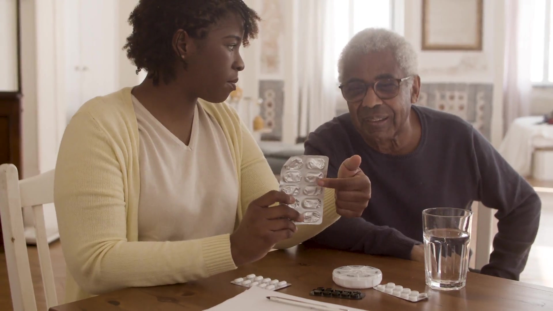 A dramatized home-care scene of a caregiver supporting an older adult at home